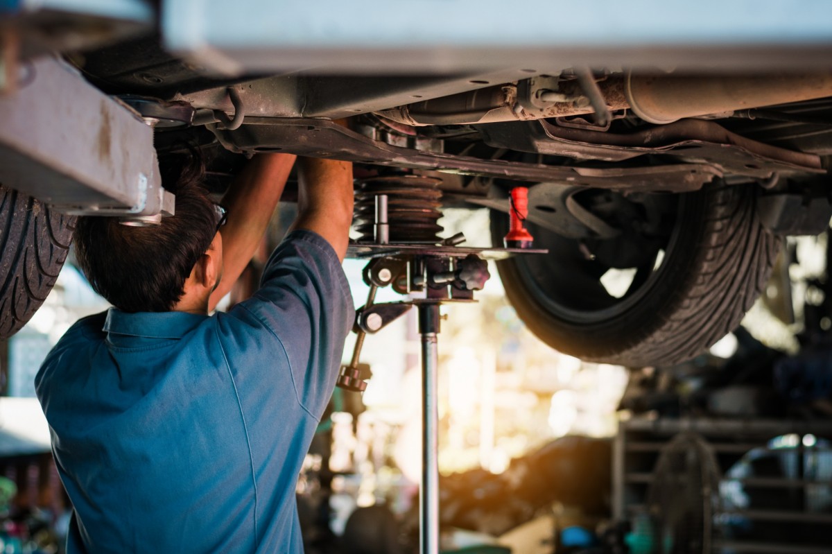 mechanic working on the suspension of a vehicle on a lift