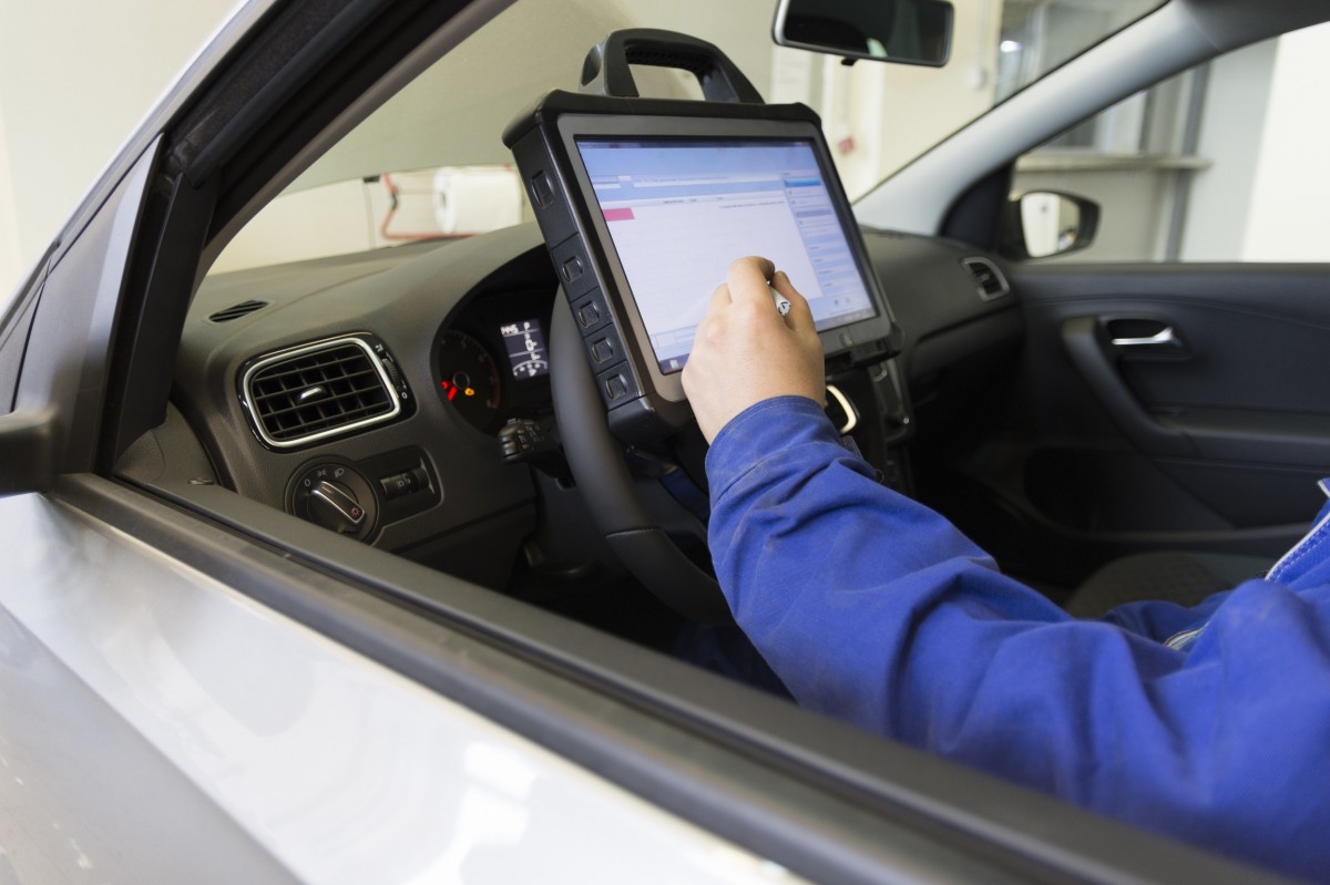 mechanic sitting in vehicle working on a screen