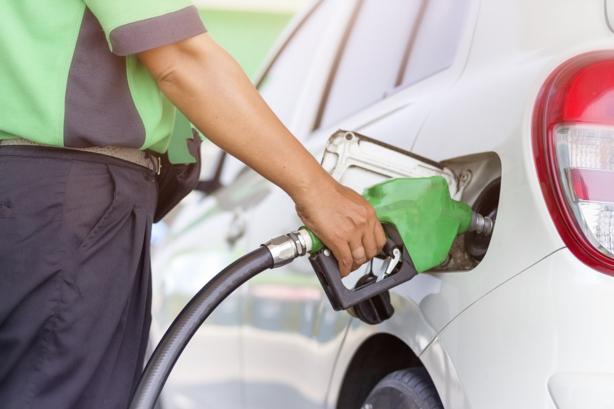 man putting gas in a vehicle at the pump 