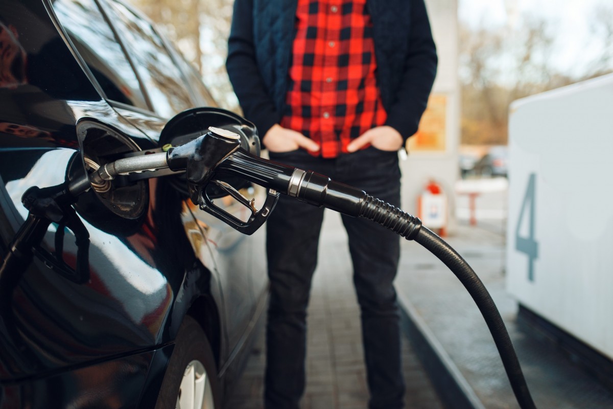 man putting gas in car