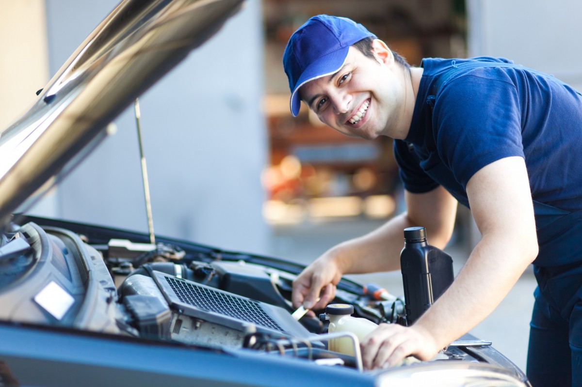 mechanic working under the hood of a car