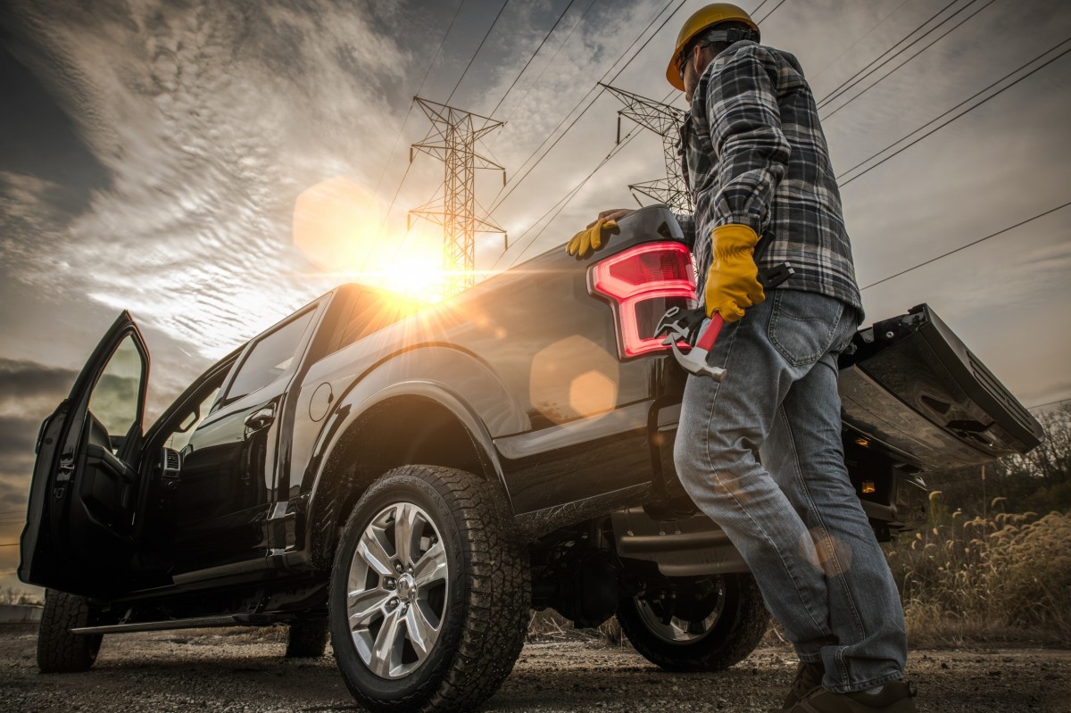 man standing by diesel truck with tools in hand